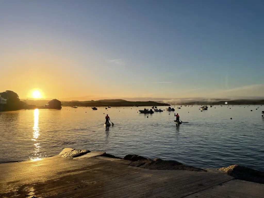 people paddleboarding the camel estuary during sunrise in cornwall