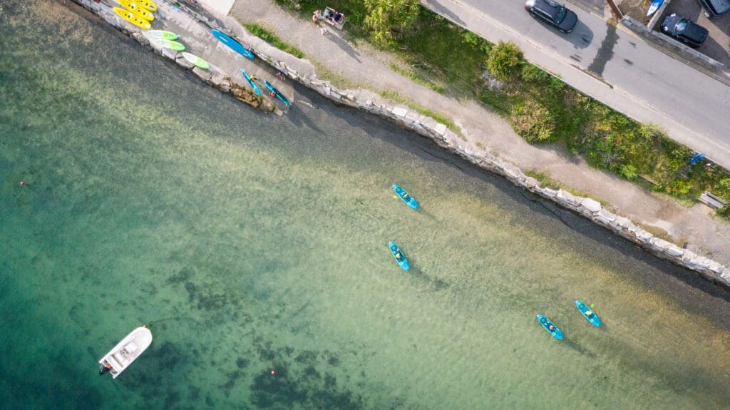 Top places to Paddleboard in Cornwall: The Best Places to Explore - Camel Ski School area shot birds view of paddleboarders with camel ski school on camel estuary