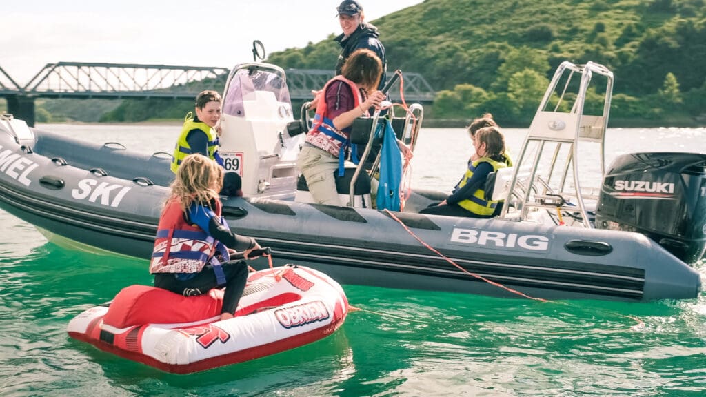 family on a boat charter doing watersports with camel ski school
