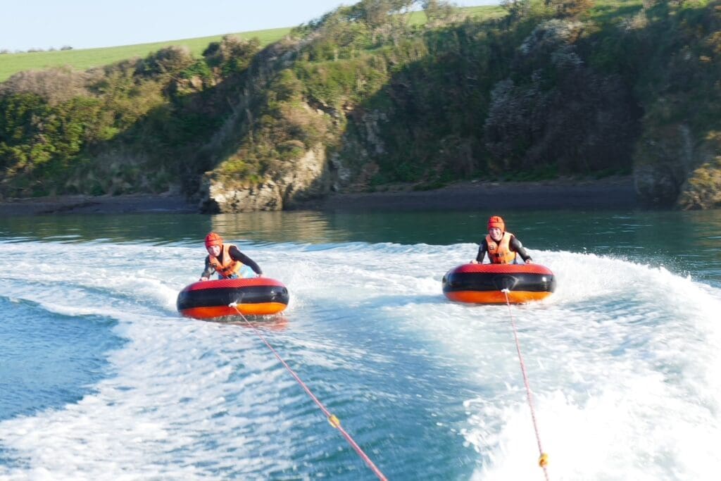 Home - Camel Ski School two people riding the chariots on the camel estuary being towed by camel ski school motorboat