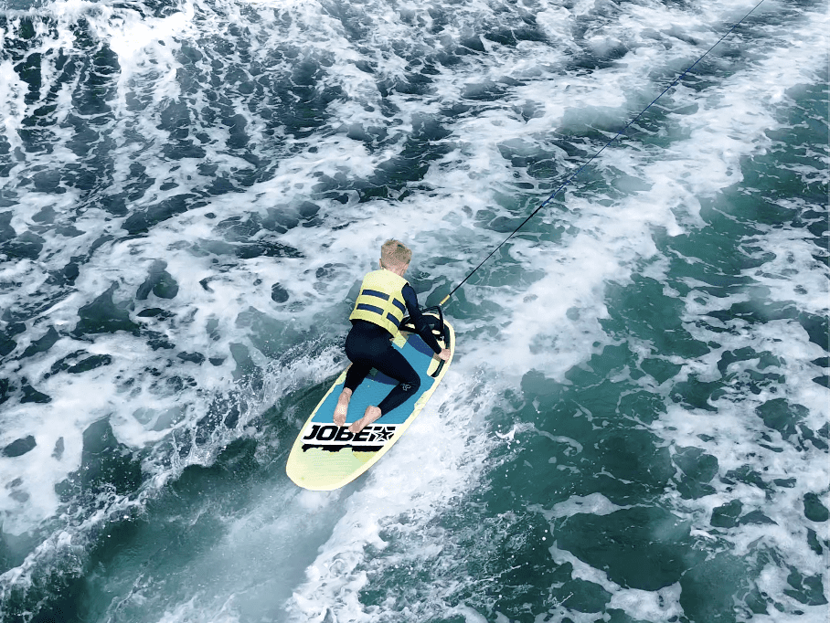 kid being towed on a multiposition board with camel ski in cornwall