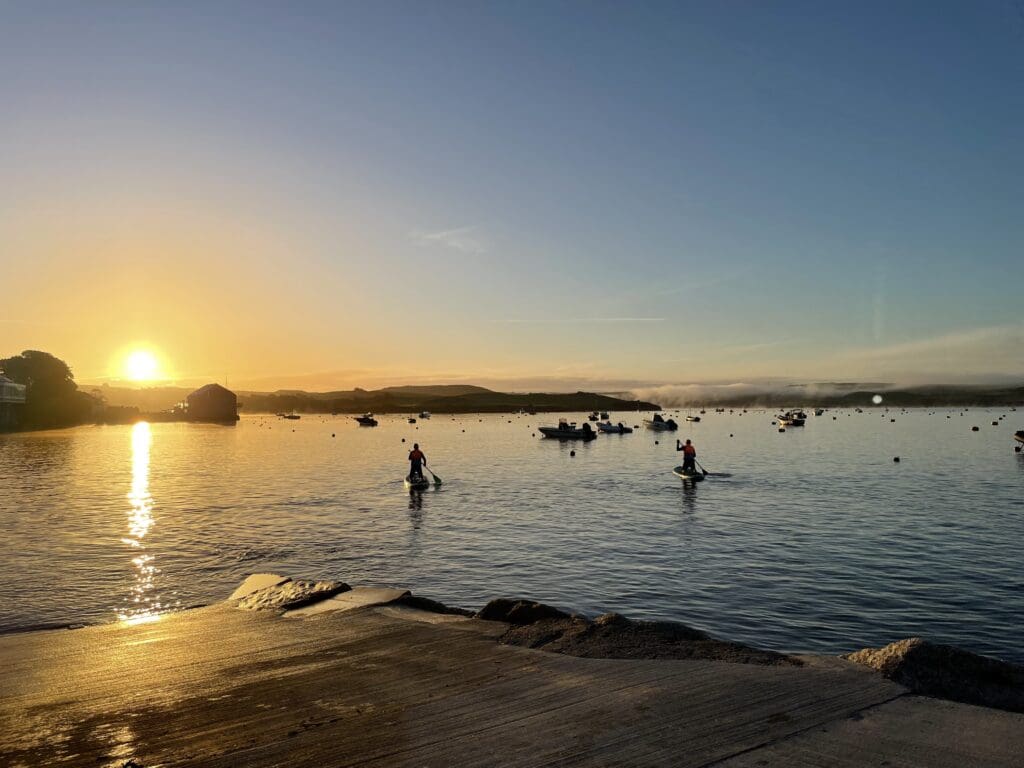 Top places to Paddleboard in Cornwall: The Best Places to Explore - Camel Ski School people paddleboarding the camel estuary during sunrise in cornwall